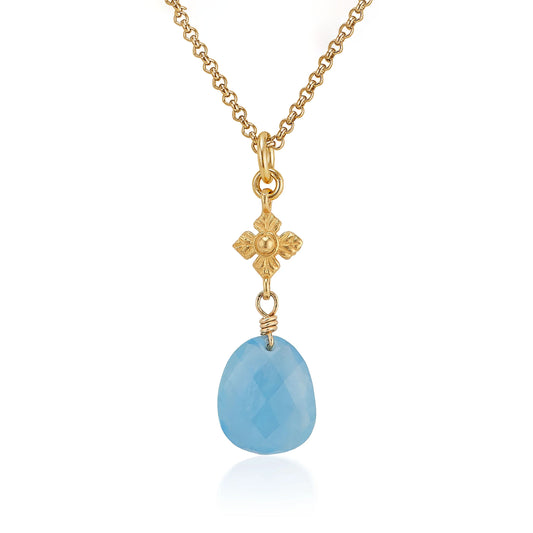 Gold necklace with a blue teardrop pendant on a white background