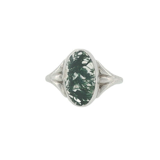 Silver ring with a green stone on a white background