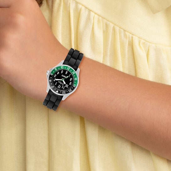 Watch with a black strap and green accents on a wrist against a yellow fabric background